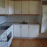 køkken med trægulv, elektrisk komfur, køleskab, hvide skabe, og let gulv